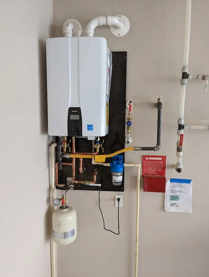 Professional plumber installing copper piping in a Corcoran home